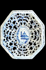 Octagonal raised plate in pierced majolica with geometric motifs and architectural scene in the center. Savona.