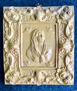 Formella in maiolica ingobbiata con busto di Madonna e Angeli al centro  e motivi floreali e rocaille sul bordo.Emilia.