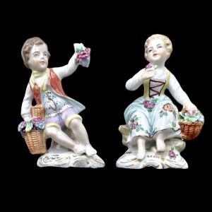 Pair of porcelain figurines depicting a female and a male character with a basket of fruit and flowers. Ginori manufacture.