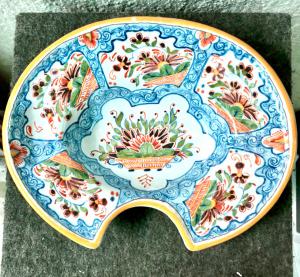 Piatto da barba decorato con cesti di fiori entro medaglioni e motivi vegetali stilizzati ,Manifattura di Delft.Olanda.