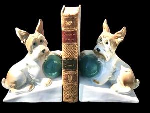 Coppia di fermalibri in porcellana raffiguranti cani terrier. Periodo Art Deco’.