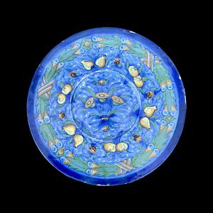 Berettino-ground majolica plate with plant motifs. Ca'Pirota manufacture. Faenza.