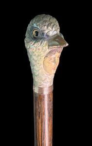 Bastone con pomolo in legno raffigurante volto femminile con maschera a forma di uccello.
