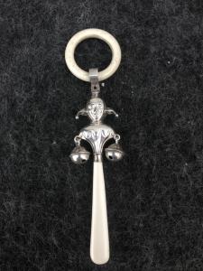 Babyrassel aus Silber, die einen Joker darstellt. Birmingham 1928. England.