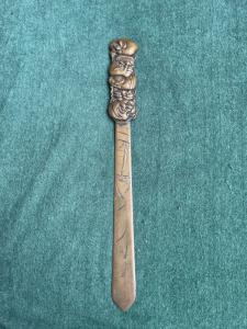 Brass letter opener with engraved naturalistic motifs and a handle with masks from the Commedia dell'Arte. Japan.