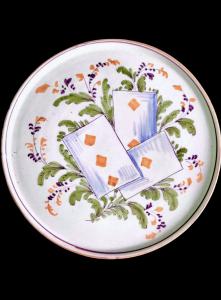 Prato de bolo/tábua de corte em faiança com decoração de motivos vegetais e cartas de baralho. Pavia.