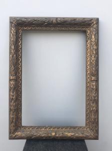 Cornice in legno intagliato e dorato con motivi vegetali in rilievo.