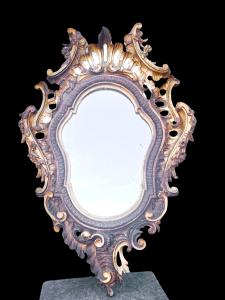 Carved and partially gilded wooden mirror with openwork, engraved with rocaille and floral and vegetal motifs.