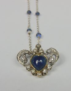 White gold necklace with heart-shaped cabochon sapphire, brilliant-cut diamonds and small opals in the chain. 1940s