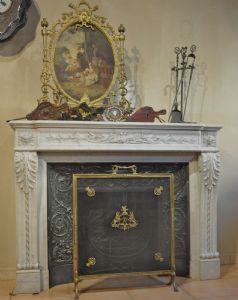 Neoclassical fireplace with reducer and front sculpted with an acanthus leaf design, bow and arrows