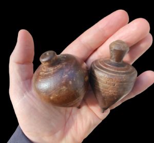 Two turned wooden spinning tops