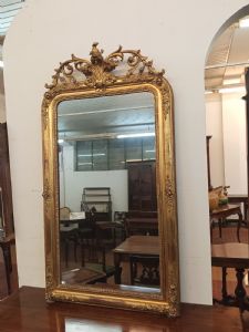 Gilded wooden mirror with crest featuring carved lily and flowers