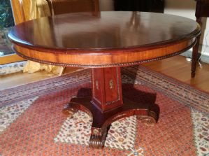 Elwgante tavolo Impero in mogano con fregi in metallo a decorazione.Diametro cm.120 Base a pilastro quadrangolare I° XIX sec.