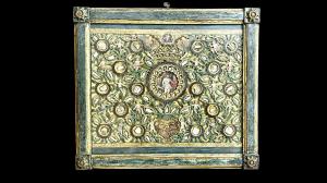 Quadro reliquiario con composizione in legno traforato in rilievo con putti e motivi vegetali.