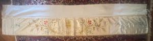 Sacred silk vestment with floral and religious embroidery.