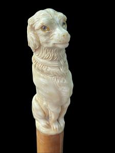 Stock mit Elfenbeinknauf in Form eines sitzenden Hundes.