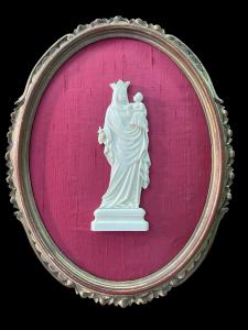 Bassorilievo Madonna con Bambino in avorio su cornice ovale in legno intagliato e dorato.