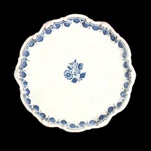 Majolica plate-chopping board with four 'pine cone' feet, polylobed rim with rocaille motifs and floral decoration in turquoise monochrome. Doccia, Ginori.
