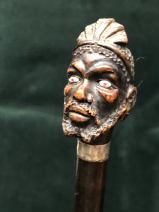 Stock mit hölzernem Knauf, der eine afrikanische männliche Figur darstellt. Italien