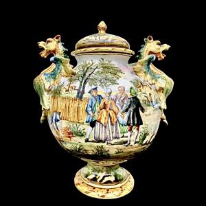 Majolica vase with lid and two dragon-shaped handles. Decoration with figures and architecture in the style of Castelli. Angelo Minghetti manufactory. Bologna.