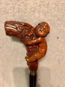 Walking stick with boxwood knob depicting a child climbing.