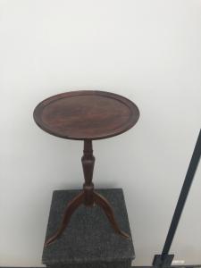 Tavolino rotondo in noce con gamba centrale e tre piedi.