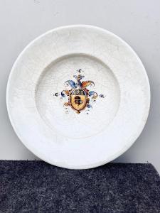 Piatto in maiolica ‘compendiaria’ con stemma nobiliare nel cavetto.Faenza.