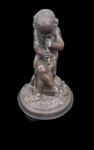 Piccola scultura in bronzo raffigurante un putto che suona il flauto.