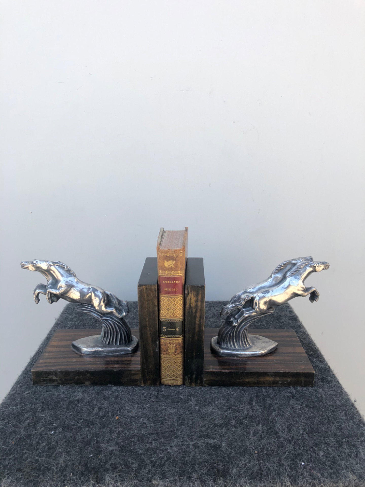 Paire de serre-livres en métal et bois représentant des chevaux de style Art déco.
