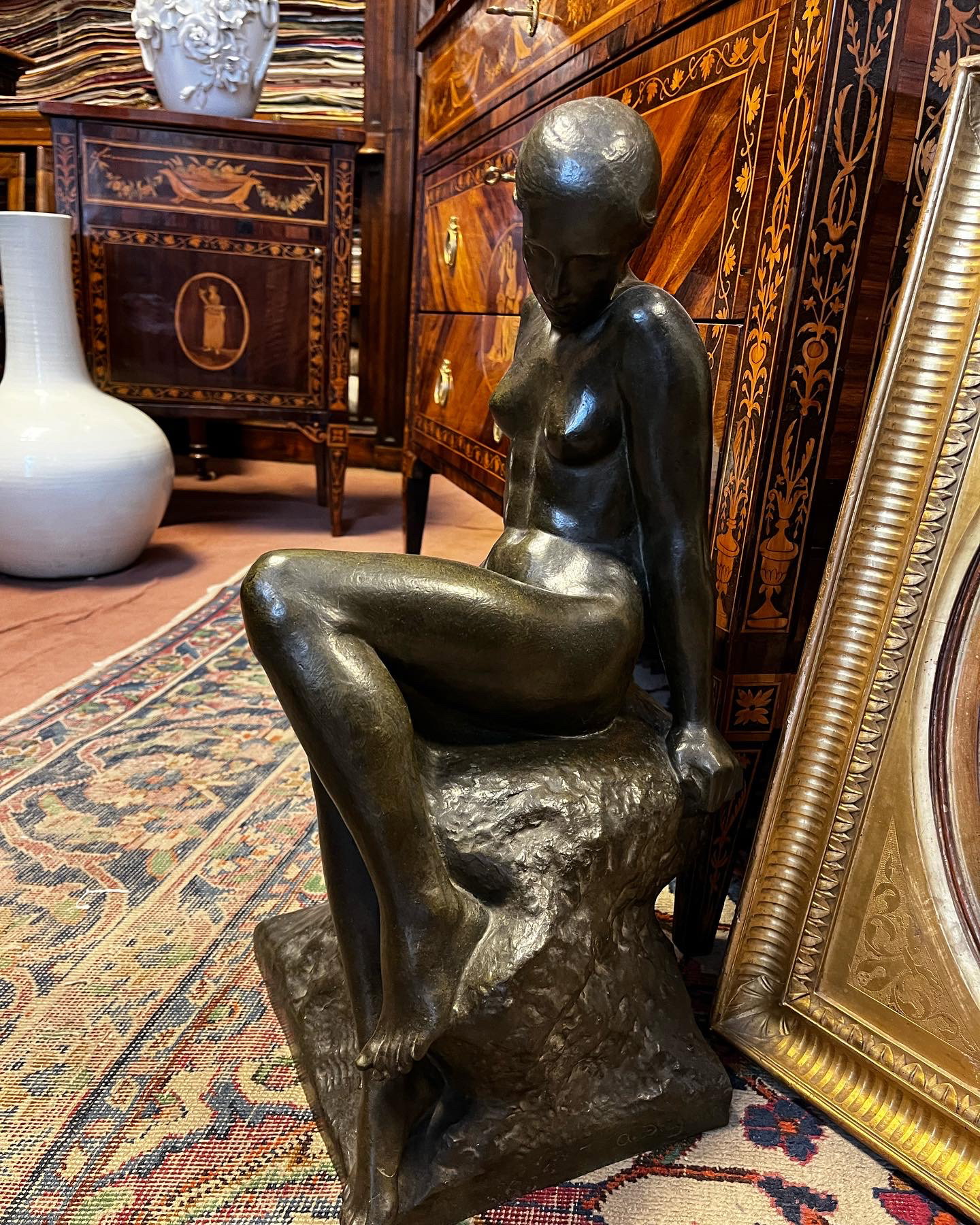 Bronze nu féminin d'Audagna Virgilio (1903). La femme est représentée assise sur un rocher servant de base à la sculpture. Les bras sont tendus, le buste est disposé frontalement. Le visage est représenté de profil avec les cheveux attachés.