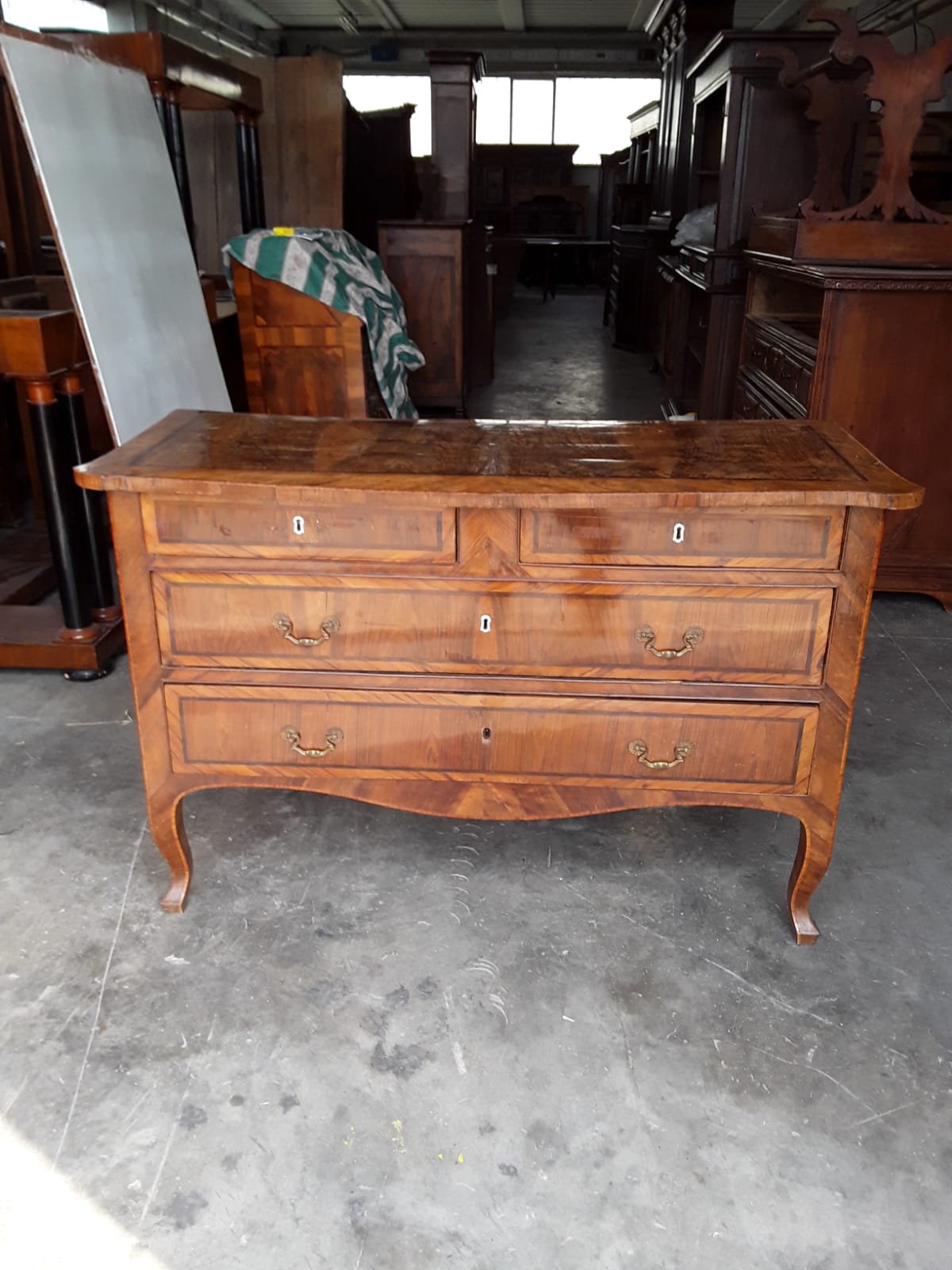 Nussbaumfurnierte Kommode mit Oliven-, Palisander- und Rosenholzintarsien. Geschwungene Platte, Möbel aus Lucca, Mitte des 18. Jahrhunderts. Außergewöhnliche Form der Beine. L135xB60xH90. Gesetzliche Gewährleistung.