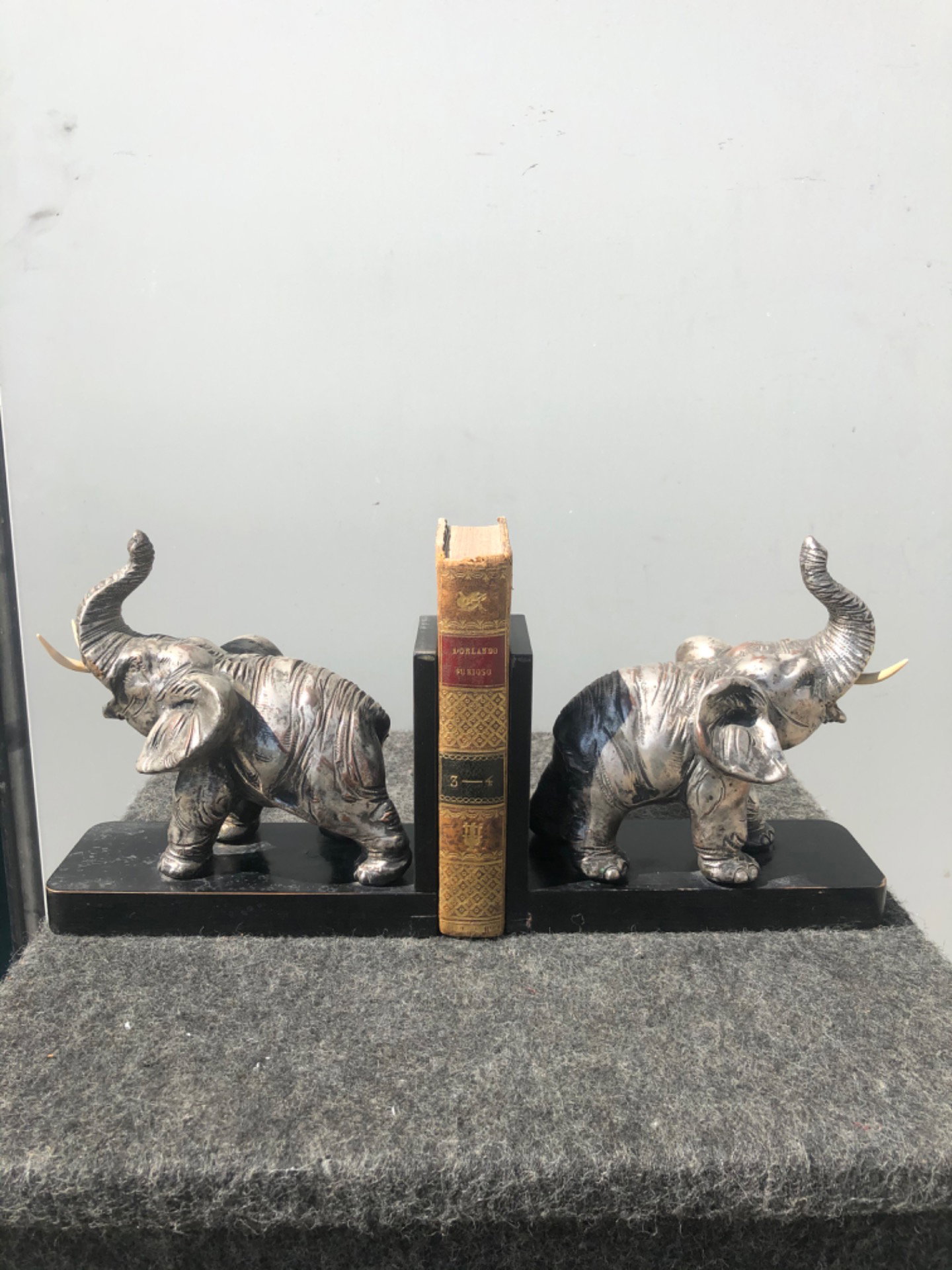 Paire de serre-livres en bois et terre cuite argentée représentant des éléphants. Signés. Italie.