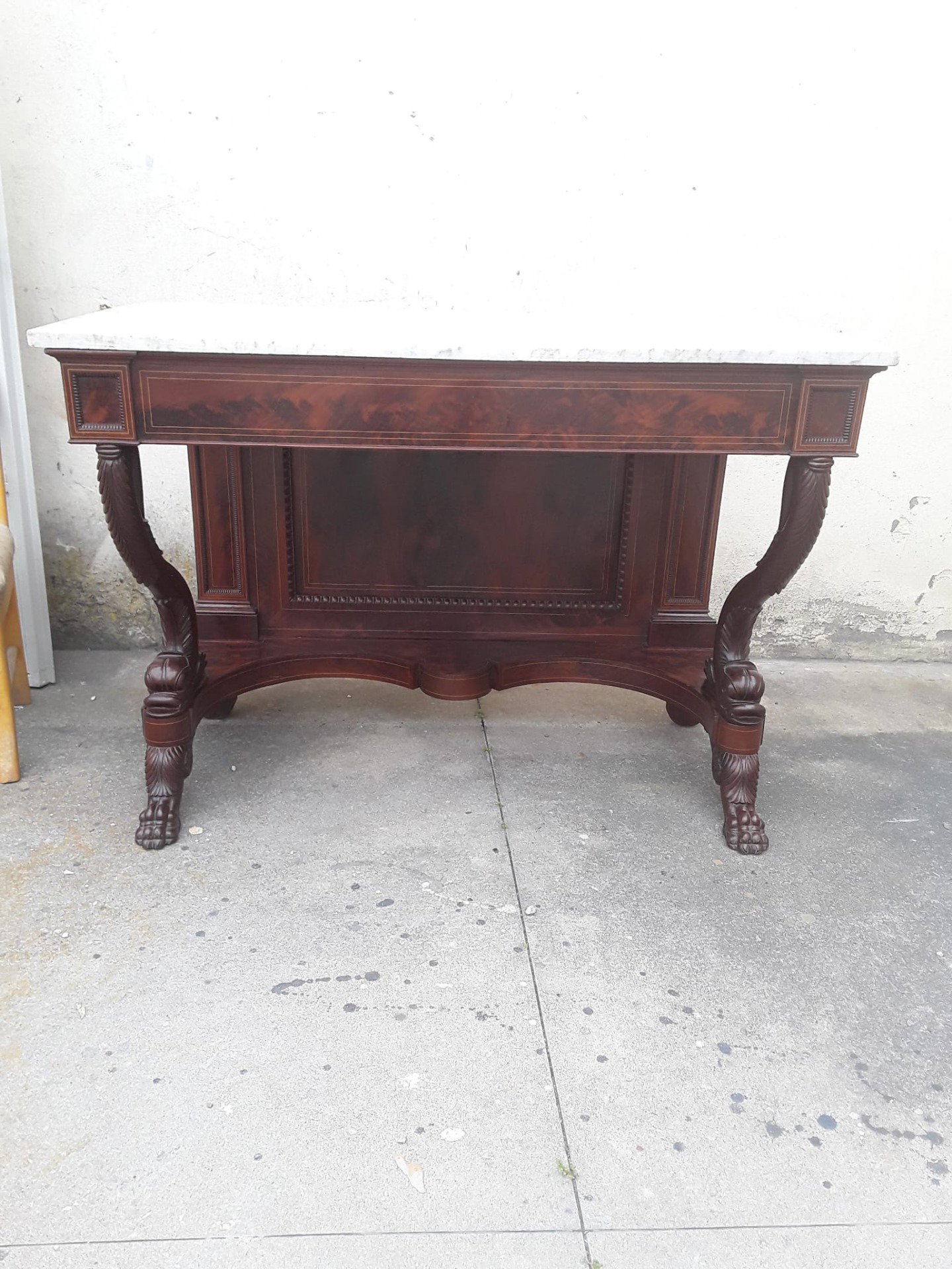 Consolesa genovesa em folha de mogno com filete de ácer e tritões, tampo em mármore de Carrara. Fabricação provável de .peters maker Genoa. Garantia de acordo com os termos legais.