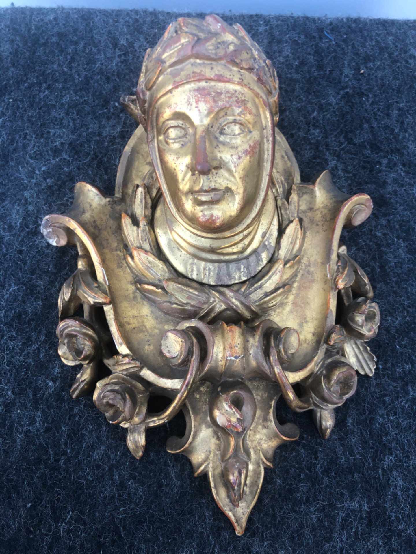 Friso de madeira entalhada e dourada com motivos vegetais estilizados e figura central de Dante.