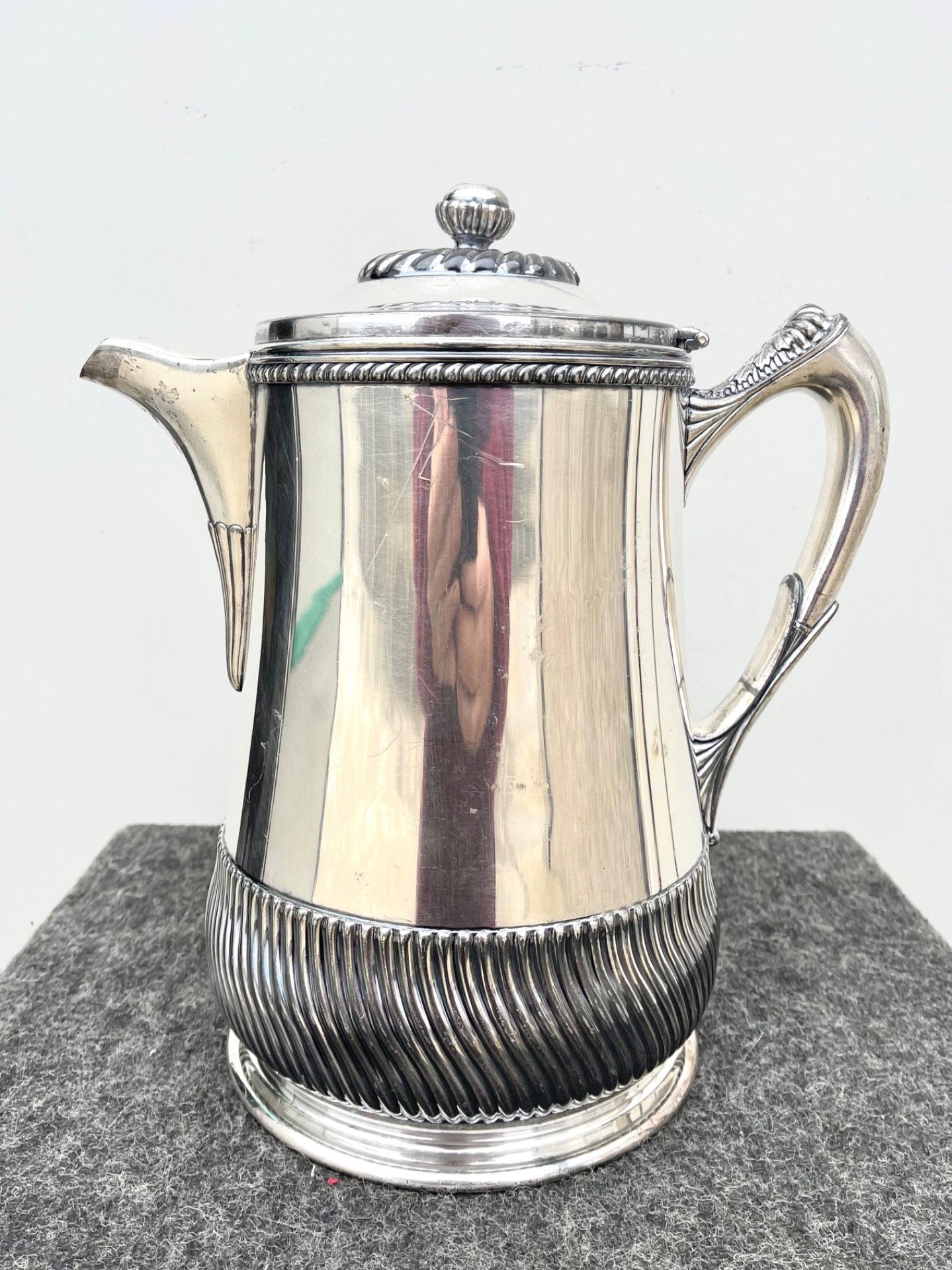 Chocolatera plateada con motivos geométricos en relieve. Estados Unidos. Firma Wilcox Silver Plate Co. Meriden. Conn y fecha 1878.