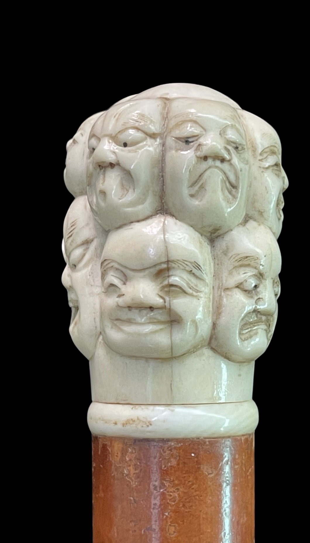 Canne avec pommeau en ivoire sculpté représentant des masques de la Comédie de l'art. Japon.