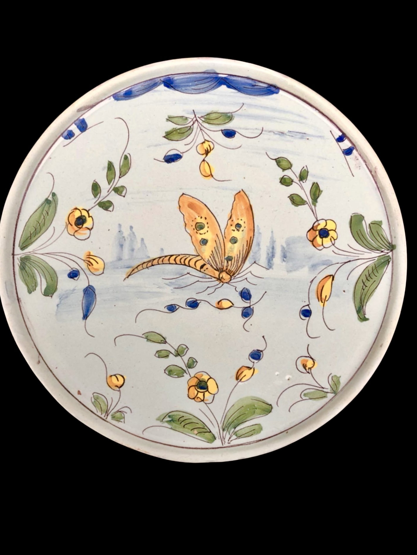 Fuente con pie de mayólica con fondo celeste con mariposa y motivos vegetales estilizados. Pavía.