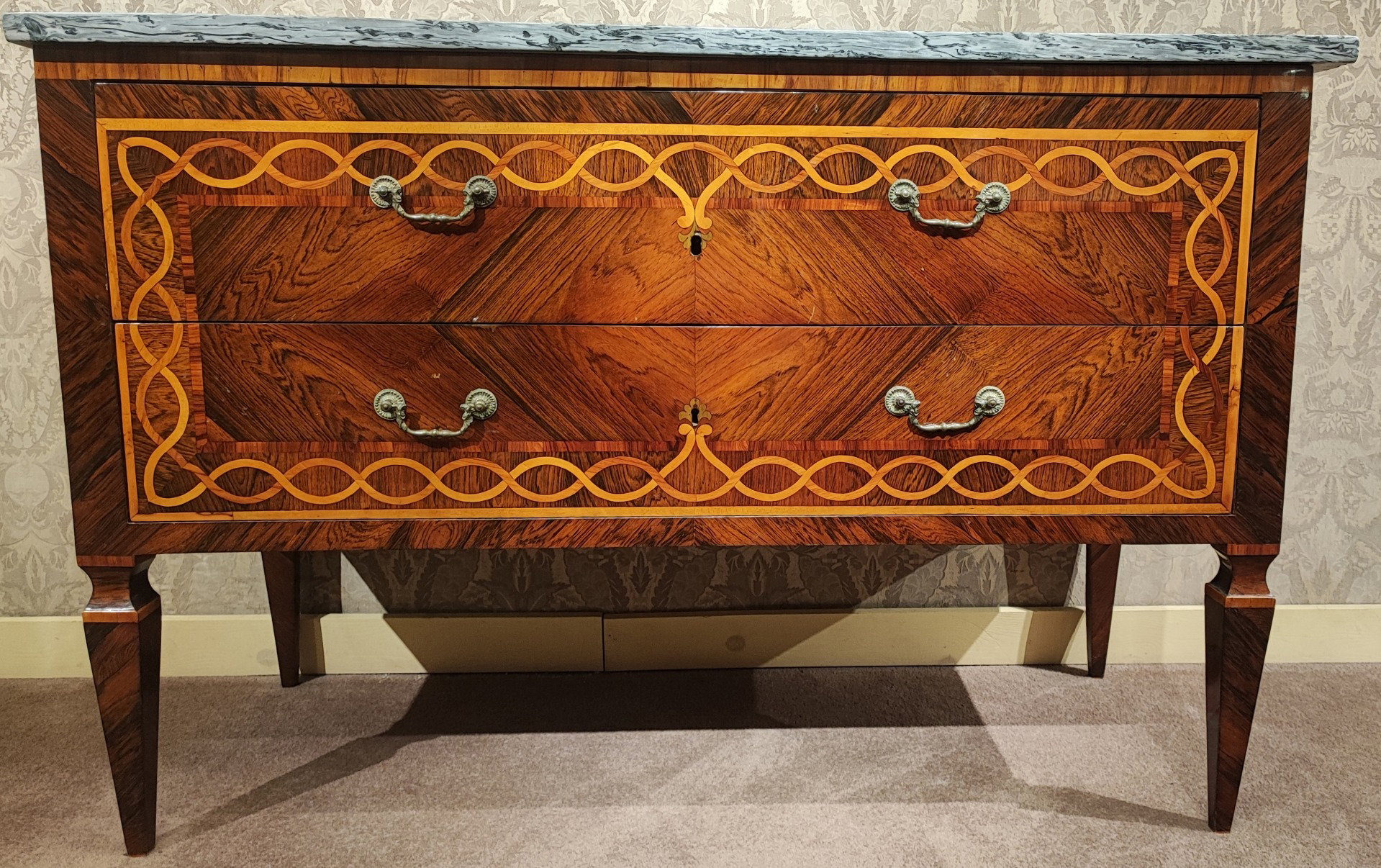 Elegante Luigi XVI Kommode komplett mit Nussbaum furniert und mit Ahornintarsien in Form eines Bandmotivs auf der Vorderseite und den Seiten verziert, ruhend auf Pyramidenstumpffüßen mit Halsband. Zeitgenössische graue Marmorplatte.