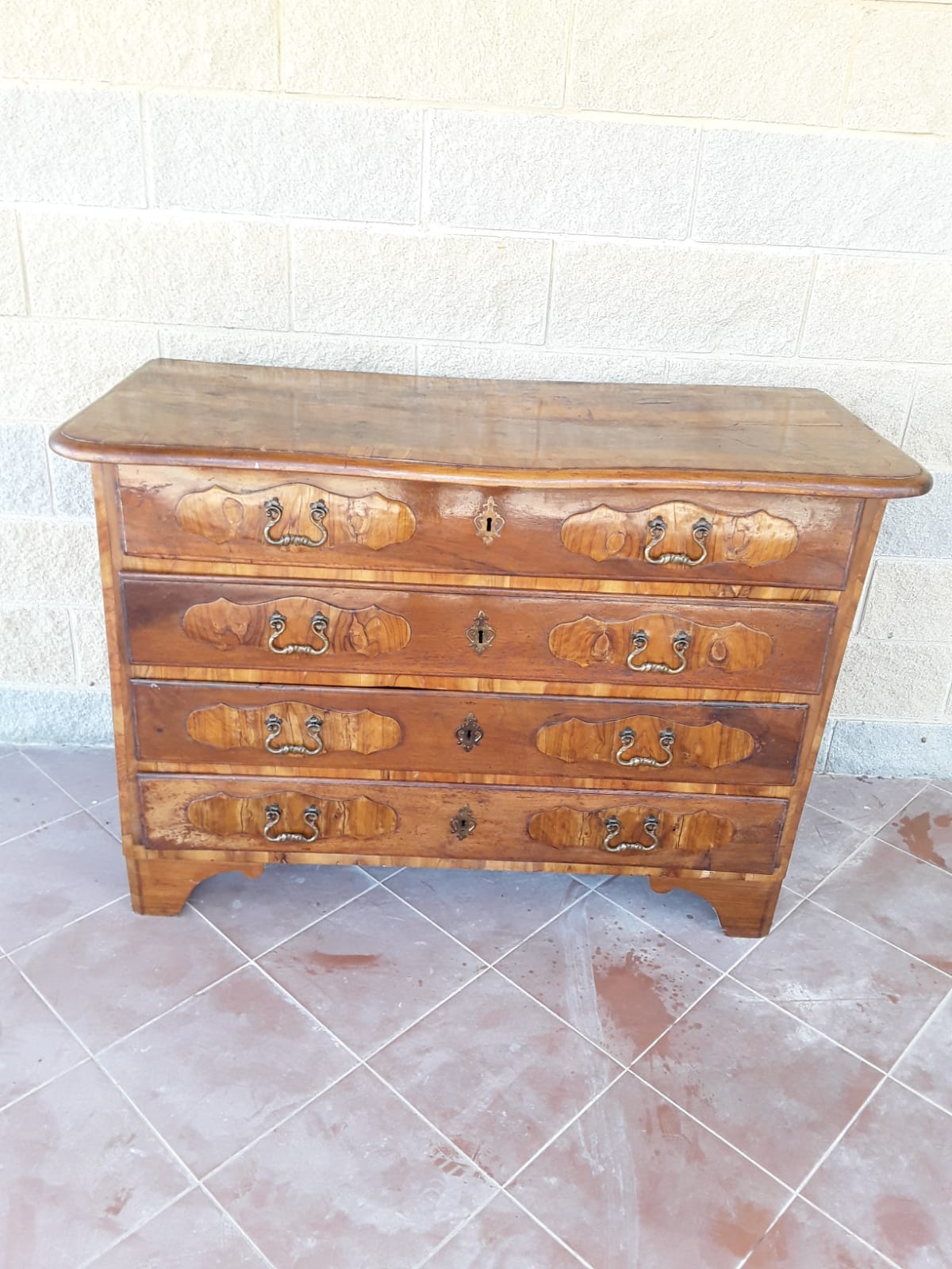 Cômoda piemontesa tampo ondulado, primeira metade do século XVIII, nogueira, painéis e filetes em oliveira. Dimensões: 130cm x 59cm x 92cm. Garantia nos termos da lei.