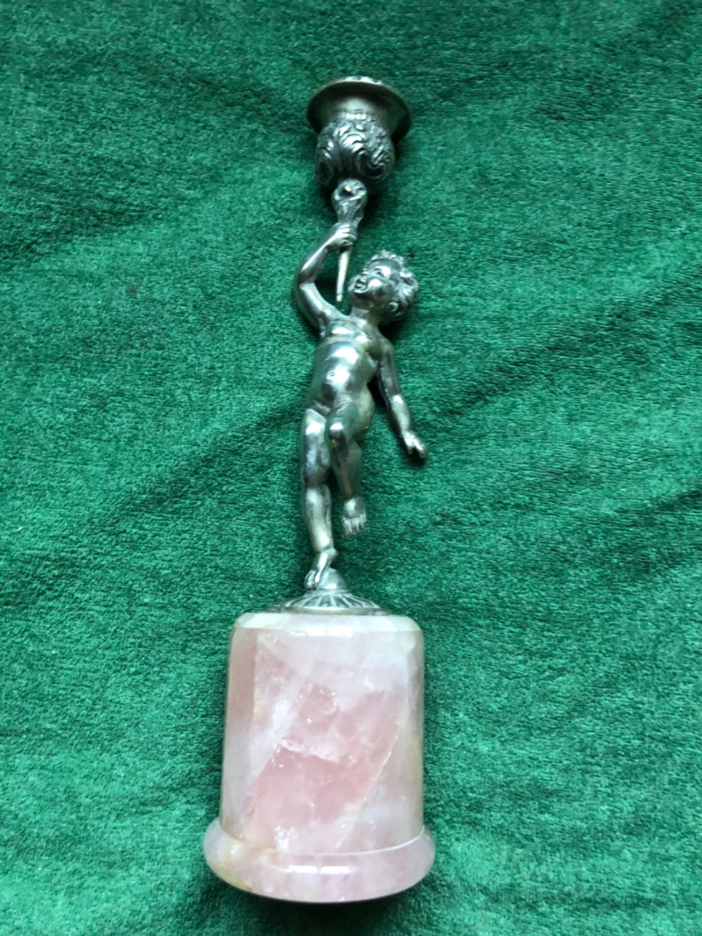 Candelero de plata con base de cuarzo rosa que representa a un niño desnudo sosteniendo el portavelas. Italia.