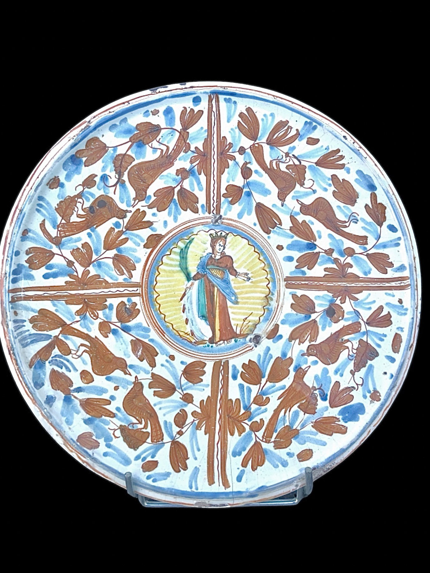Alzada de mayólica con decoración caligráfica-naturalista con la figura de Santa Catalina de Alejandría en el centro sosteniendo una palma, una espada y un libro. Deruta.