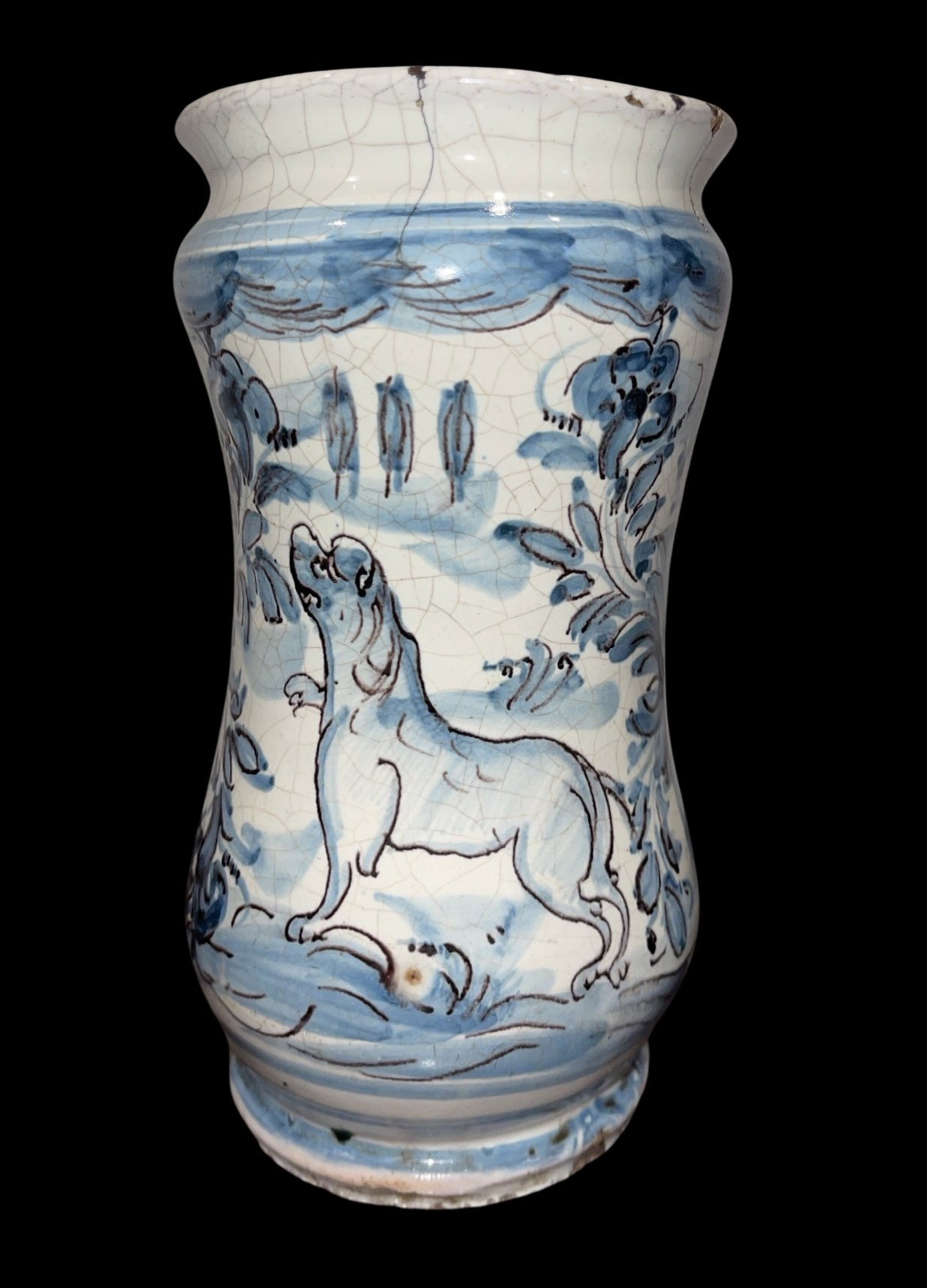 Albarello de mayólica con cuerpo ensanchado en el centro y decoración monocromática turquesa con figura de perro en un entorno rural. Nápoles.