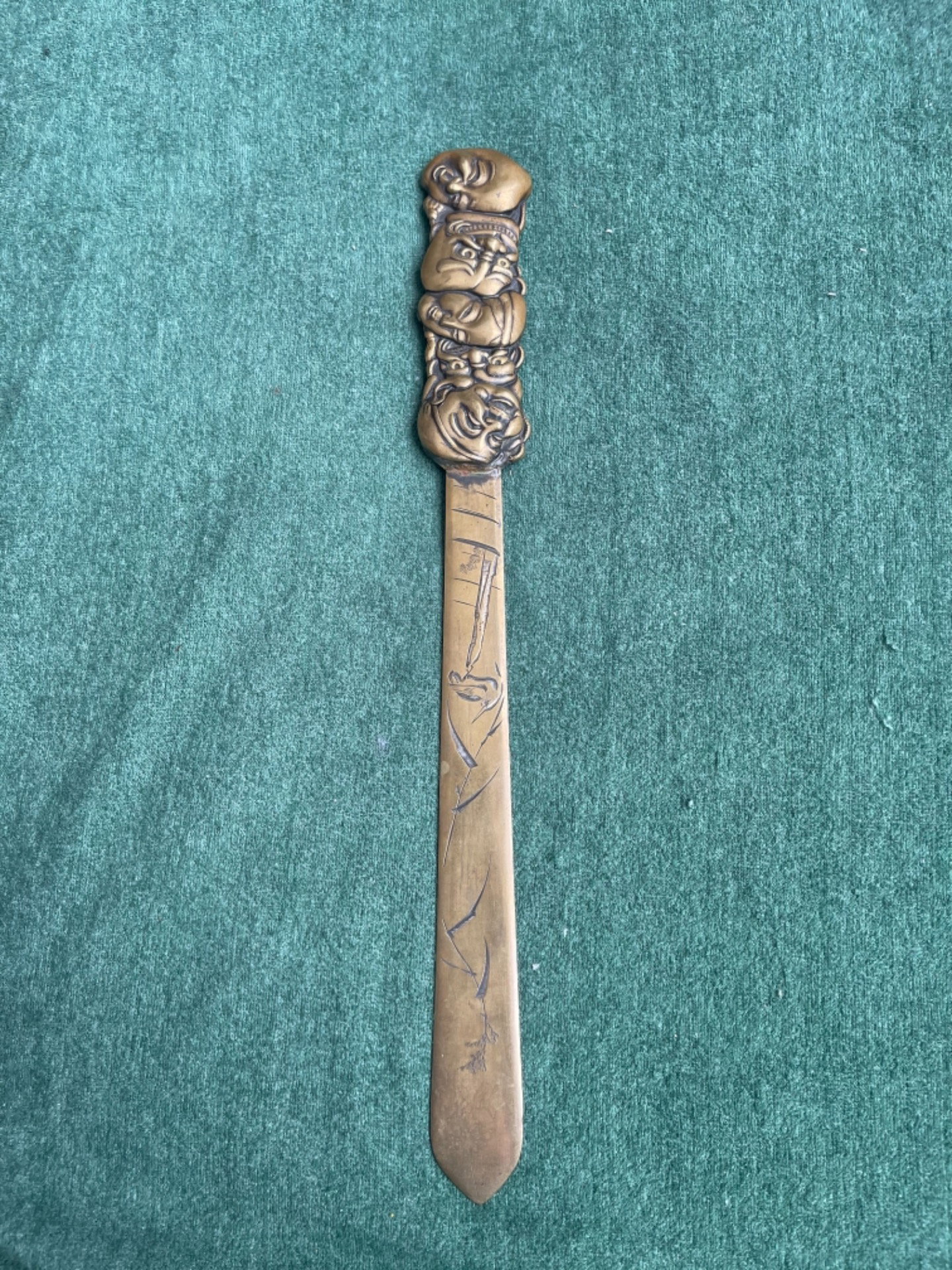 Tagliacarte in ottone con  motivi naturalistici incisi e manico con maschere della commedia dell’arte.Giappone.