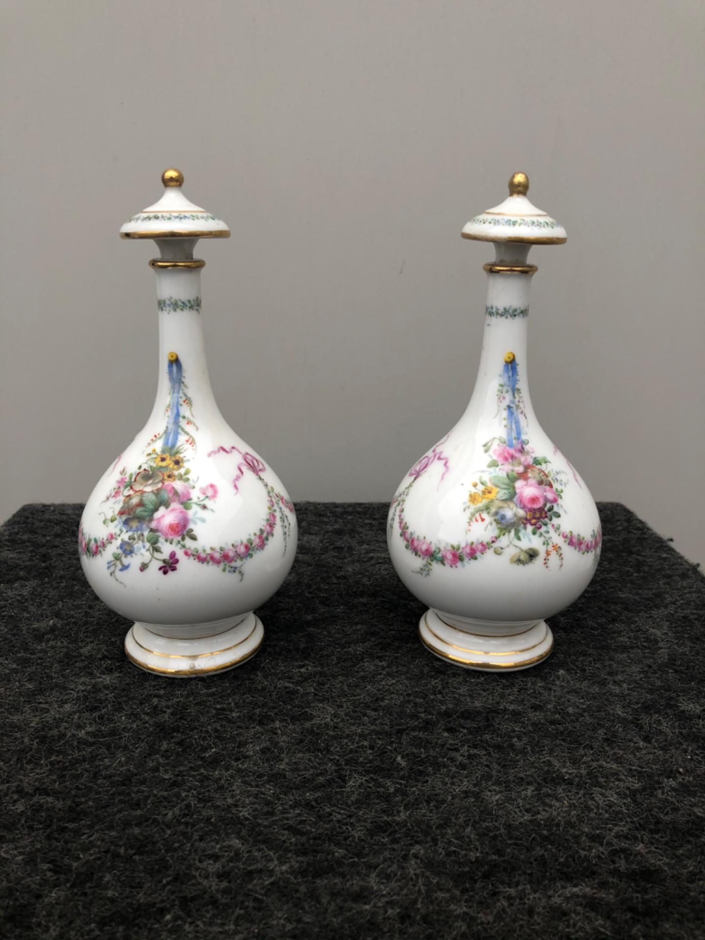 Par de frascos de perfume de porcelana decorados com flores e troféus. França.