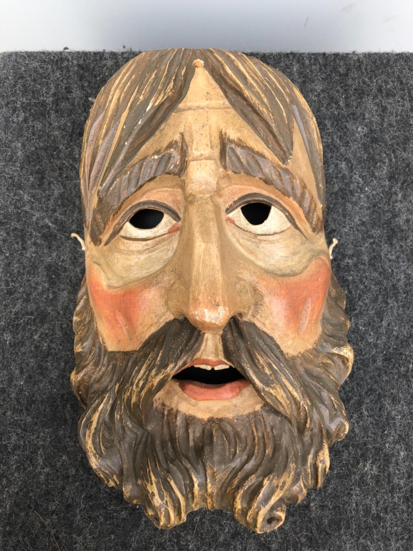 Geschnitzte und bemalte Holzmaske, die eine männliche Figur mit Bart darstellt. Italien