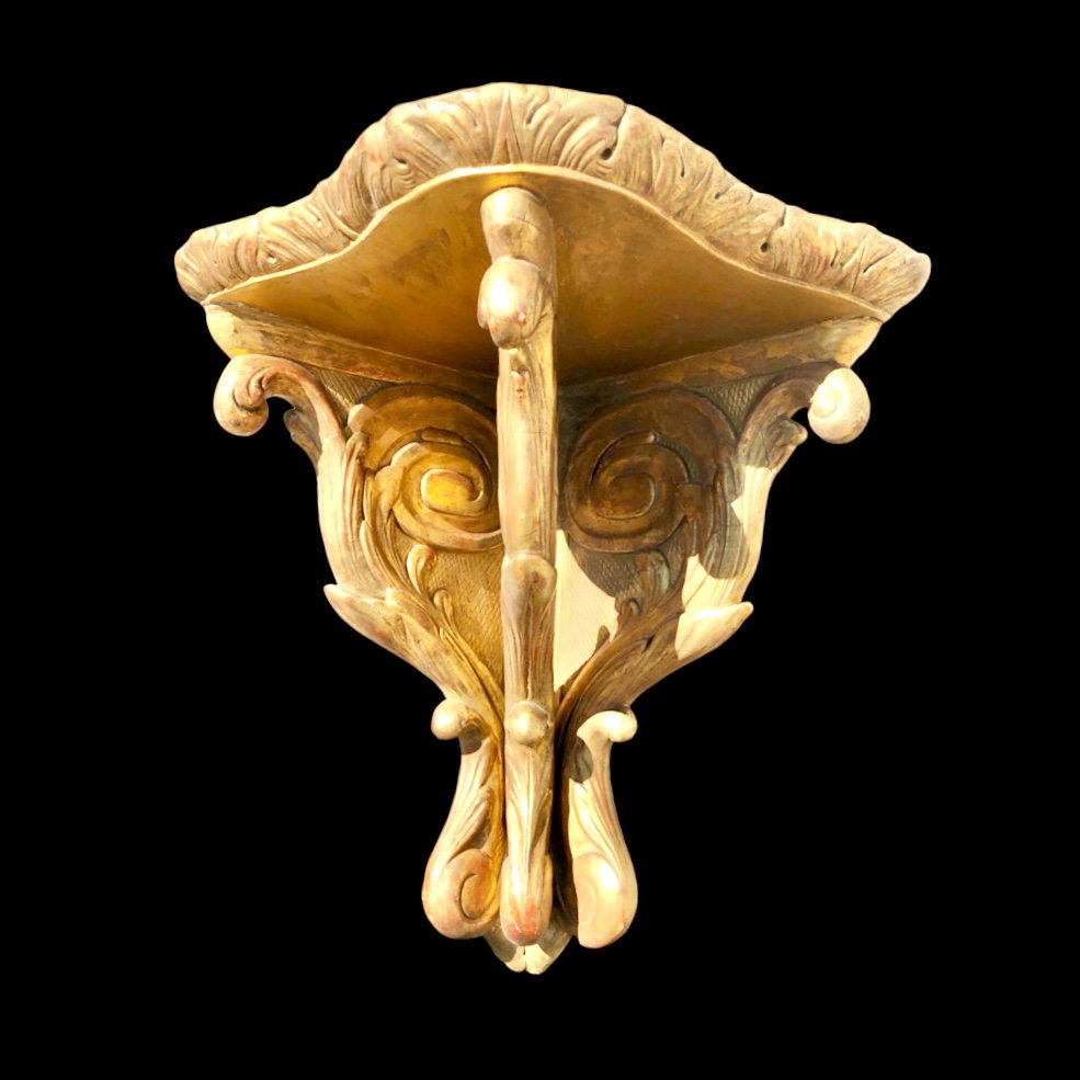 Étagère d'angle en bois sculpté et feuille d'or avec motifs végétaux stylisés.
