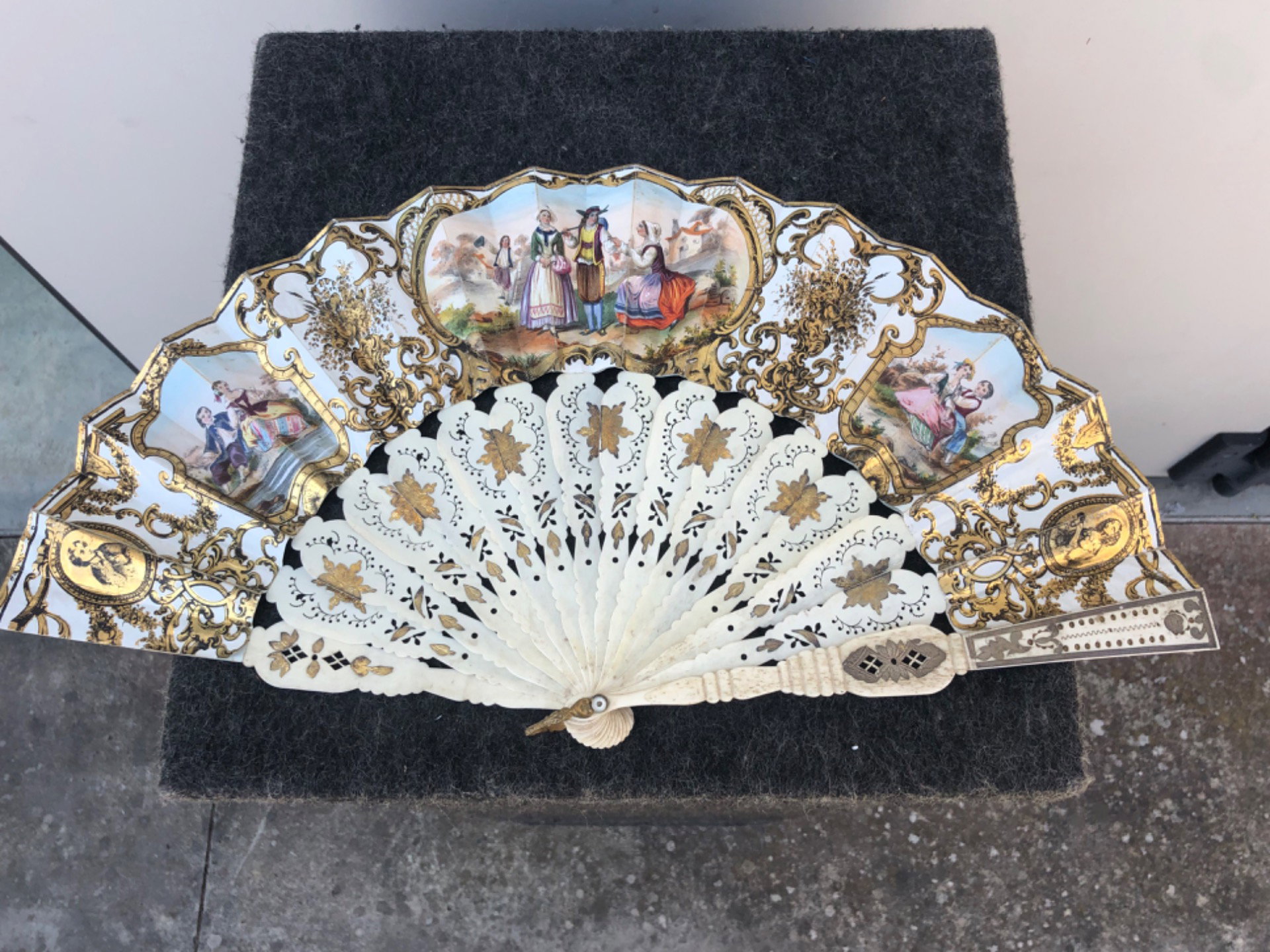 Éventail avec brins ajourés et dorés, et panache en papier avec impressions aquarellées représentant des scènes galantes et champêtres. France.