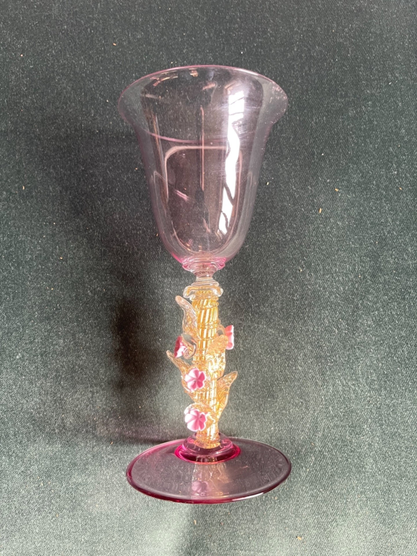 Bicchiere in vetro iridato con foglia oro e applicazioni floreali.Firma sulla base.Murano.