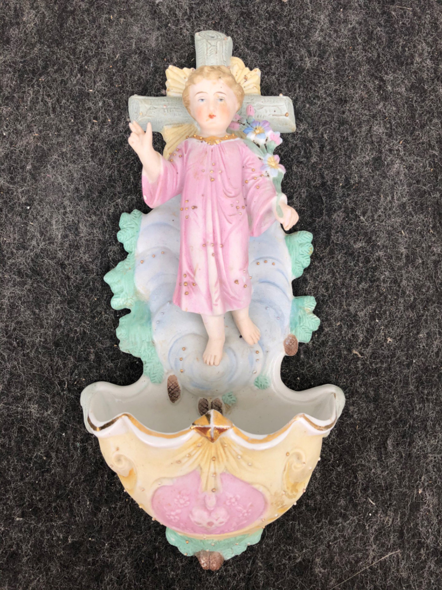 Bénitier en porcelaine biscuit avec une figurine de l'enfant Jésus bénissant portant un bouquet de fleurs. Allemagne.