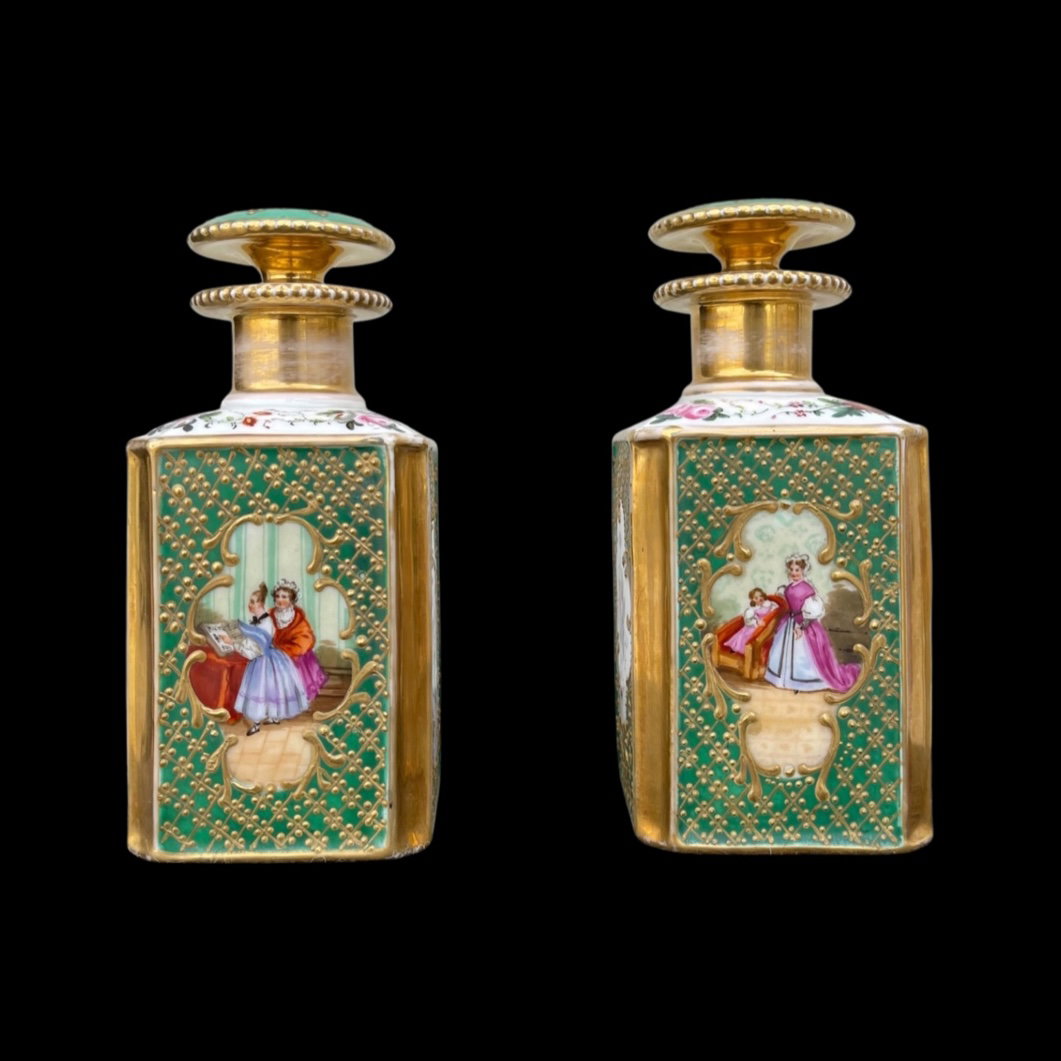 Pair of porcelain perfume bottles with female figures and floral and gold decorations. France.